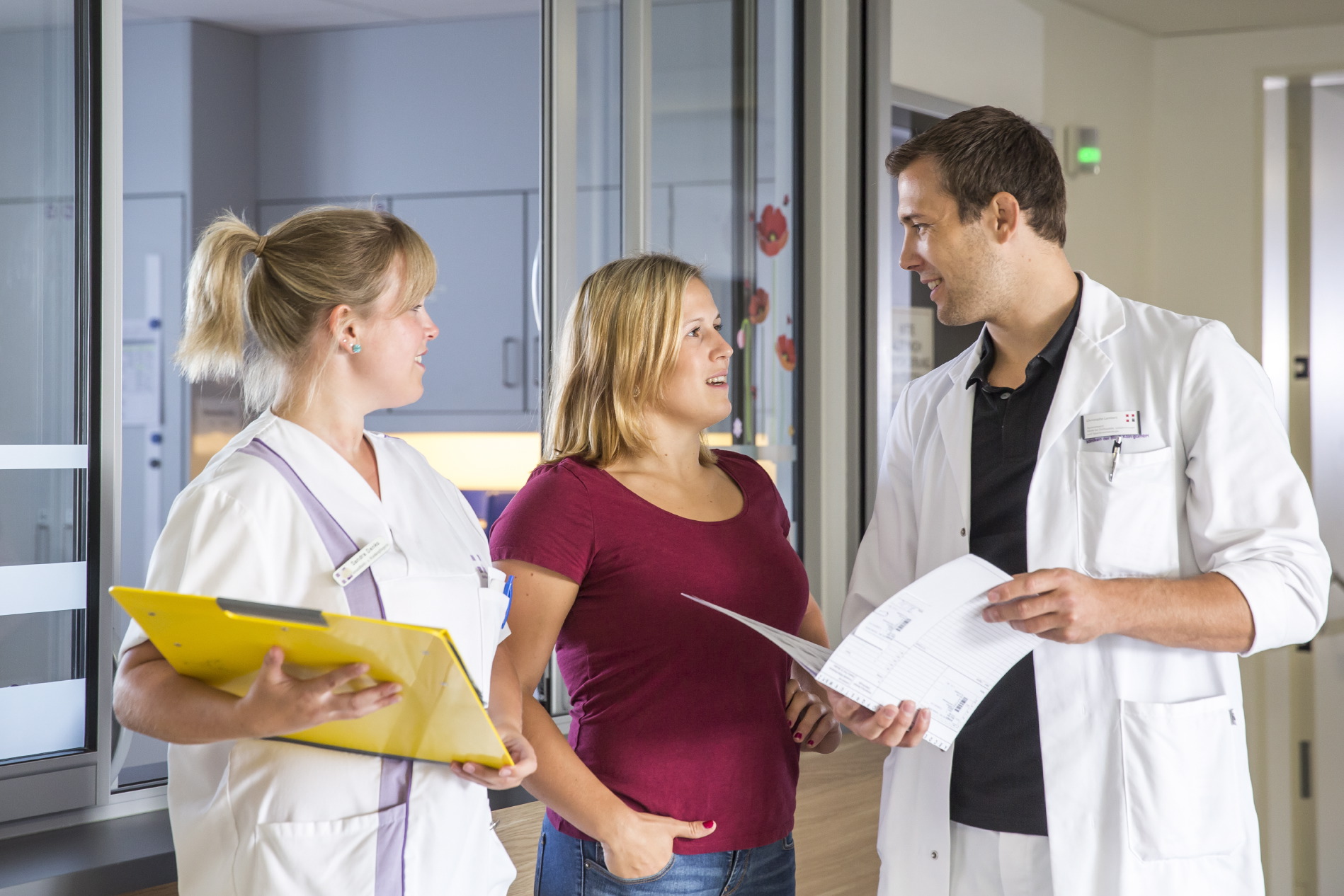 Ein Team mit Arzt und Schwestern besprechen sich in einem Klinik Flur