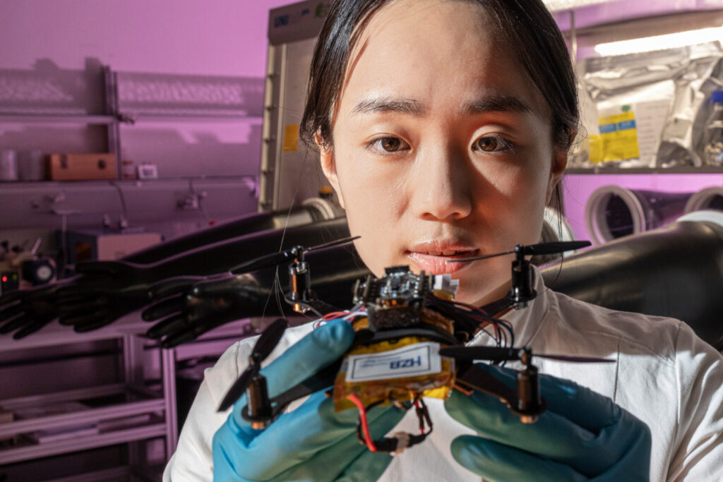 Wissenschaftlerin hält eine kleine Drohne in der Hand