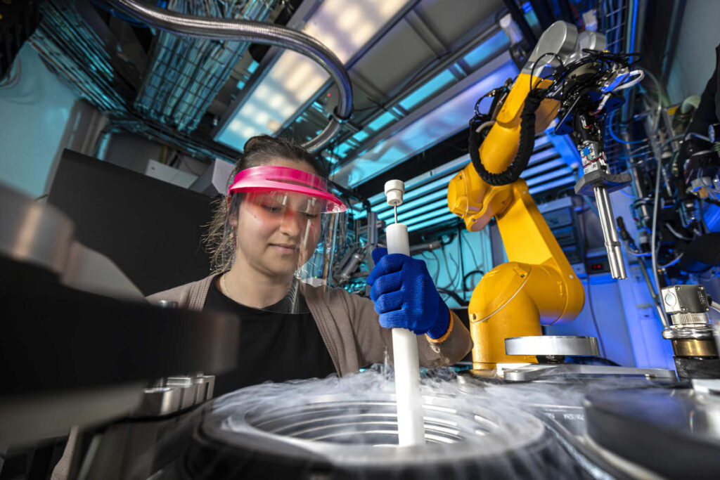 Eine Wissenschaftlerin entnimmt eine Probe aus einem Stickstoffbehälter