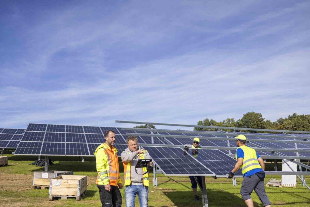 Mehrere Arbeiter beim Aufbau einer Solaranlage